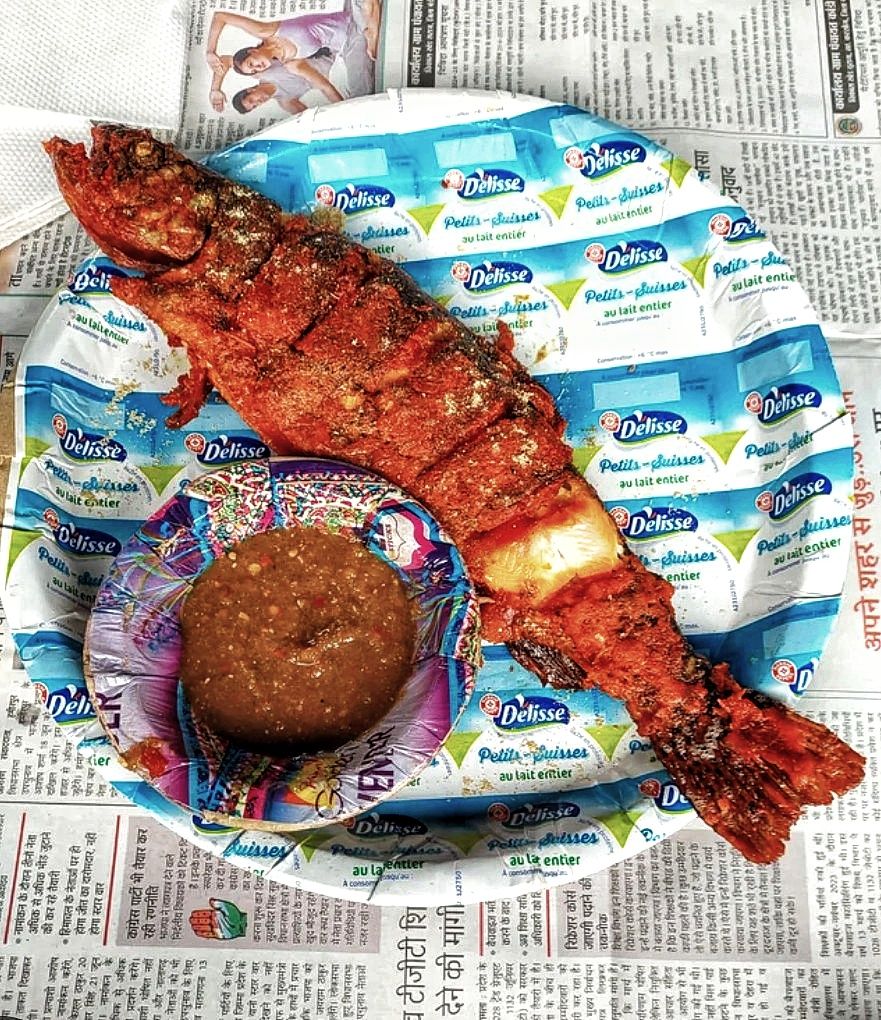 Freshly grilled trout fish served with spicy chutney on a plate in Barot Valley, Himachal Pradesh.