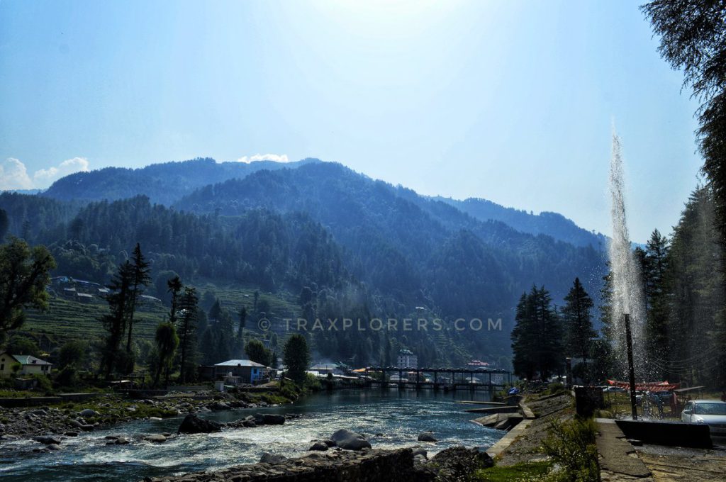 Barot village view with mountains, forest and a water fountain in Himachal Pradesh